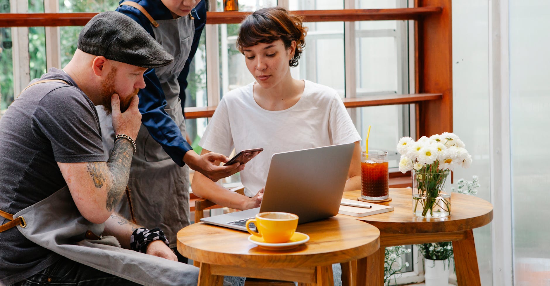 serious colleagues sitting at table with gadgets in cafe